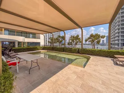a patio with a table and chairs and a pool at Frank Porter - Marina Vista Tower 1 in Dubai