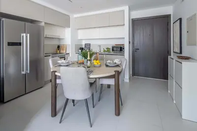a kitchen with a table with chairs and a refrigerator at Frank Porter - Marina Vista Tower 1 in Dubai