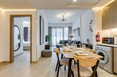 a dining room and living room with a table and a kitchen at GlobalStay 1 Bedroom Apartment for 4 Guests Azizi Riviera 42 Dubai in Dubai
