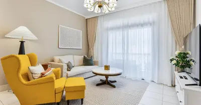a living room with a yellow chair and a couch at Downtown 2BHK Iconic Burj Khalifa Views in Dubai
