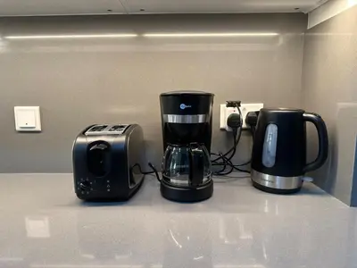a coffee maker and a toaster on a counter at Cozy & Stylish Studio in Silicon Oasis in Dubai