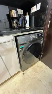 a microwave oven sitting under a counter in a kitchen at Cozy & Stylish Studio in Silicon Oasis in Dubai