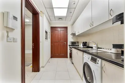 a kitchen with a washer and dryer at Splendid Studio near Canal & famous Golf Clubs in Dubai