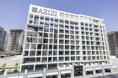 a tall white building with a aktec sign on it at Bloomfields Lumière Stu Azizi Riviera in Dubai