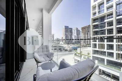 a balcony with two chairs and a view of a city at Bloomfields Lumière Stu Azizi Riviera in Dubai