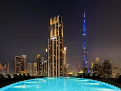 a large swimming pool with a city skyline at night at GuestReady - High-Floor 2BR | City and Canal View in Dubai