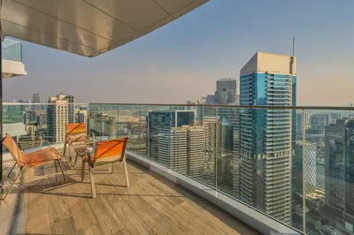 a balcony with two chairs and a view of a city at GuestReady - High-Floor 2BR | City and Canal View in Dubai