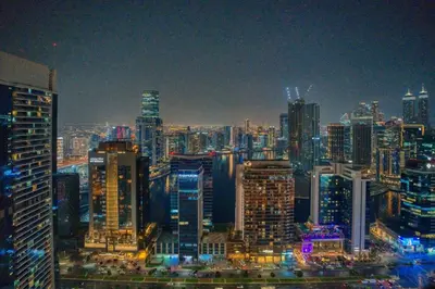 a city skyline at night with many tall buildings at GuestReady - High-Floor 2BR | City and Canal View in Dubai