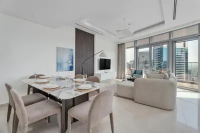 a living room with a dining room table and chairs at GuestReady - High-Floor 2BR | City and Canal View in Dubai