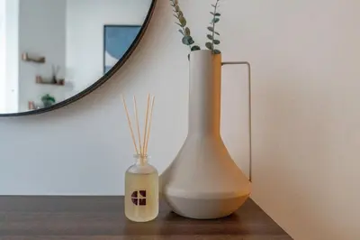 two white vases sitting on a table with a mirror at GuestReady - High-Floor 2BR | Canal and City View in Dubai