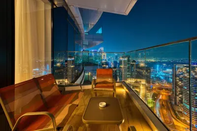 a balcony with a view of a city at night at GuestReady - High-Floor 2BR | Canal and City View in Dubai