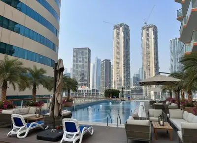 a pool in the middle of a city with tall buildings at Binghatti Millennium Studio Apartment in Dubai
