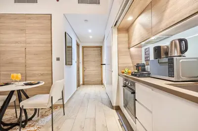 a small kitchen with a table and a microwave at Modern Studio in Studio One Tower, Dubai Marina in Dubai