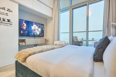 a bedroom with a large bed and a tv at Modern Studio in Studio One Tower, Dubai Marina in Dubai
