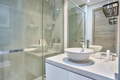 a white bathroom with a sink and a shower at Modern Studio in Studio One Tower, Dubai Marina in Dubai