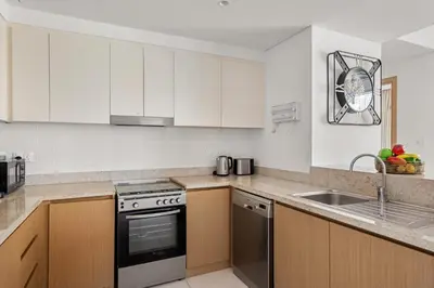 a kitchen with white cabinets and a sink at VayK - Spacious 2BR in Dubai Creek Harbour in Dubai