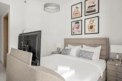 a bedroom with a bed with a tv on it at VayK - Spacious 2BR in Dubai Creek Harbour in Dubai
