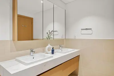 a bathroom with two sinks and a large mirror at VayK - Spacious 2BR in Dubai Creek Harbour in Dubai