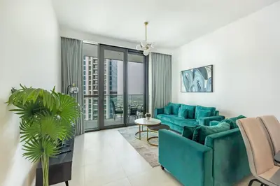 a living room with a blue couch and a table at Central 2BR Downtown Views EB in Dubai