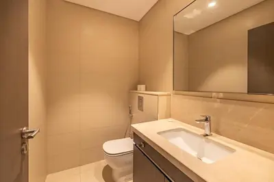 a bathroom with a toilet and a sink and a mirror at Central 2BR Downtown Views EB in Dubai