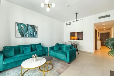 a living room with a blue couch and a table at Central 2BR Downtown Views EB in Dubai