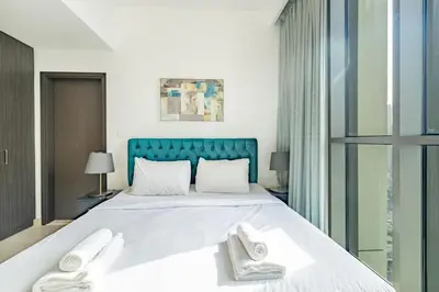 a bedroom with a large bed with two white towels at Central 2BR Downtown Views EB in Dubai