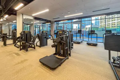 a gym with rows of exercise equipment in a building at Peninsula Five Luxurious Business Bay Studio in Dubai