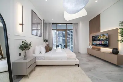 a bedroom with a large bed and a tv at Peninsula Five Luxurious Business Bay Studio in Dubai