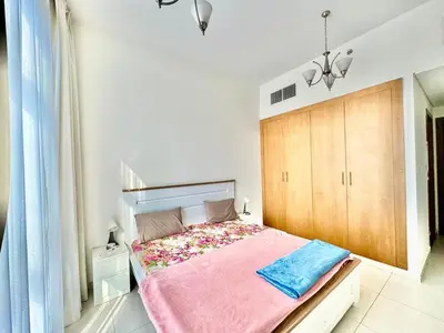 a bedroom with a large bed with a wooden headboard at Perfect choice for a big family in Dubai