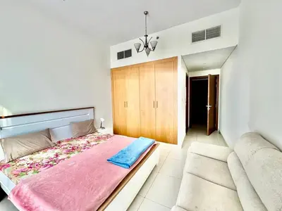 a bedroom with a large bed and a couch at Perfect choice for a big family in Dubai