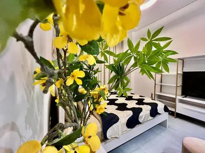 a vase filled with yellow flowers in a room at Karama Apple building in Dubai