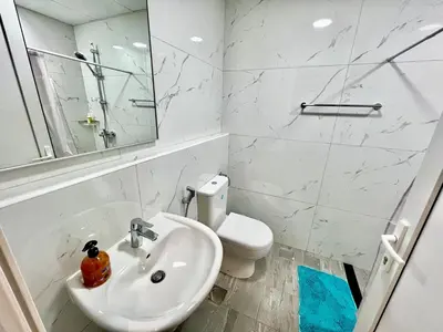 a white bathroom with a sink and a toilet at Karama Apple building in Dubai