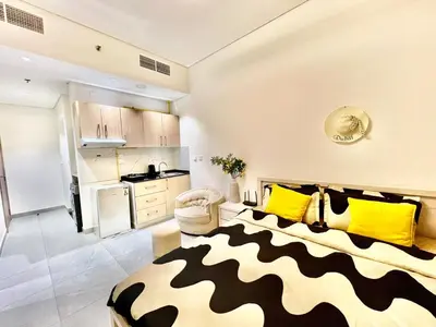 a living room with a bed with yellow and black pillows at Karama Apple building in Dubai