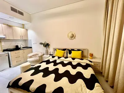 a bedroom with a large bed with yellow and black pillows at Karama Apple building in Dubai