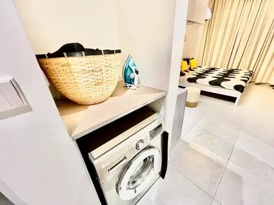 a laundry room with a washing machine and a basket on a counter at Karama Apple building in Dubai