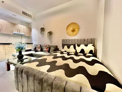 a bedroom with a zebra print bed and a couch at Karama pretty unit near metro in Dubai