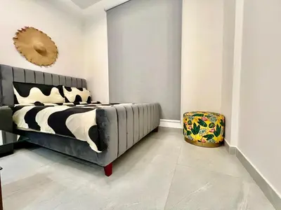 a bedroom with a black and white bed and a stool at Karama pretty unit near metro in Dubai