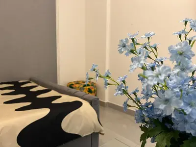 a room with a couch and a vase of blue flowers at Karama pretty unit near metro in Dubai