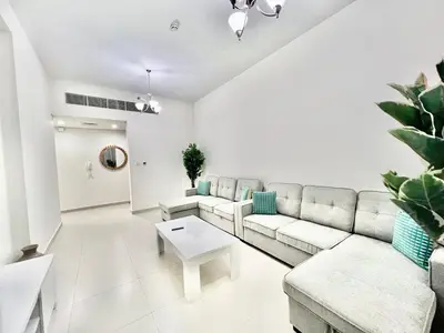 a living room with a couch and a table at Not far from metro Spacious in Dubai