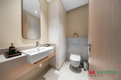 a bathroom with a white sink and a toilet at SML Vacation Homes at Vida Dubai Mall - Apartments with Burj Khalifa Views & access to the Dubai Mall in Dubai
