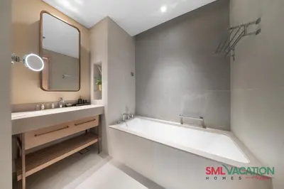 a bathroom with a tub and a sink and a mirror at SML Vacation Homes at Vida Dubai Mall - Apartments with Burj Khalifa Views & access to the Dubai Mall in Dubai