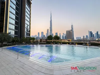 a large swimming pool with a city skyline in the background at SML Vacation Homes at Vida Dubai Mall - Apartments with Burj Khalifa Views & access to the Dubai Mall in Dubai