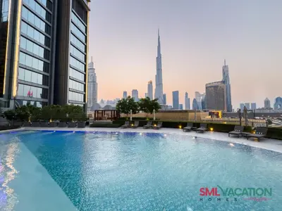 a large swimming pool with a city skyline in the background at SML Vacation Homes at Vida Dubai Mall - Apartments with Burj Khalifa Views & access to the Dubai Mall in Dubai