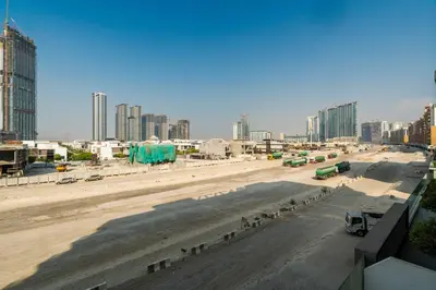 an empty road in a city with tall buildings at Stylish Studio with Gym & Pool in Azizi Riviera in Dubai
