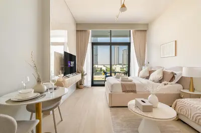a living room with a couch and a table at Stylish Studio with Gym & Pool in Azizi Riviera in Dubai