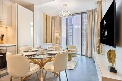 a dining room and living room with a table and chairs at STAY BY LATINEM Luxury 1BR Holiday Home CC 1806 Near Burj Khalifa in Dubai