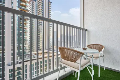 a balcony with a table and chairs and a view at STAY BY LATINEM Luxury 1BR Holiday Home CC 1806 Near Burj Khalifa in Dubai