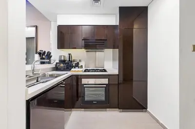 a kitchen with wooden cabinets and a stove top oven at Beautiful Canal View Majestine Damac in Dubai