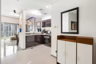 a kitchen with white cabinets and a mirror on the wall at Beautiful Canal View Majestine Damac in Dubai