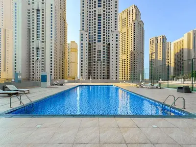 a large swimming pool in a city with tall buildings at Spacious 2 Bedroom Apartment in JBR in Dubai